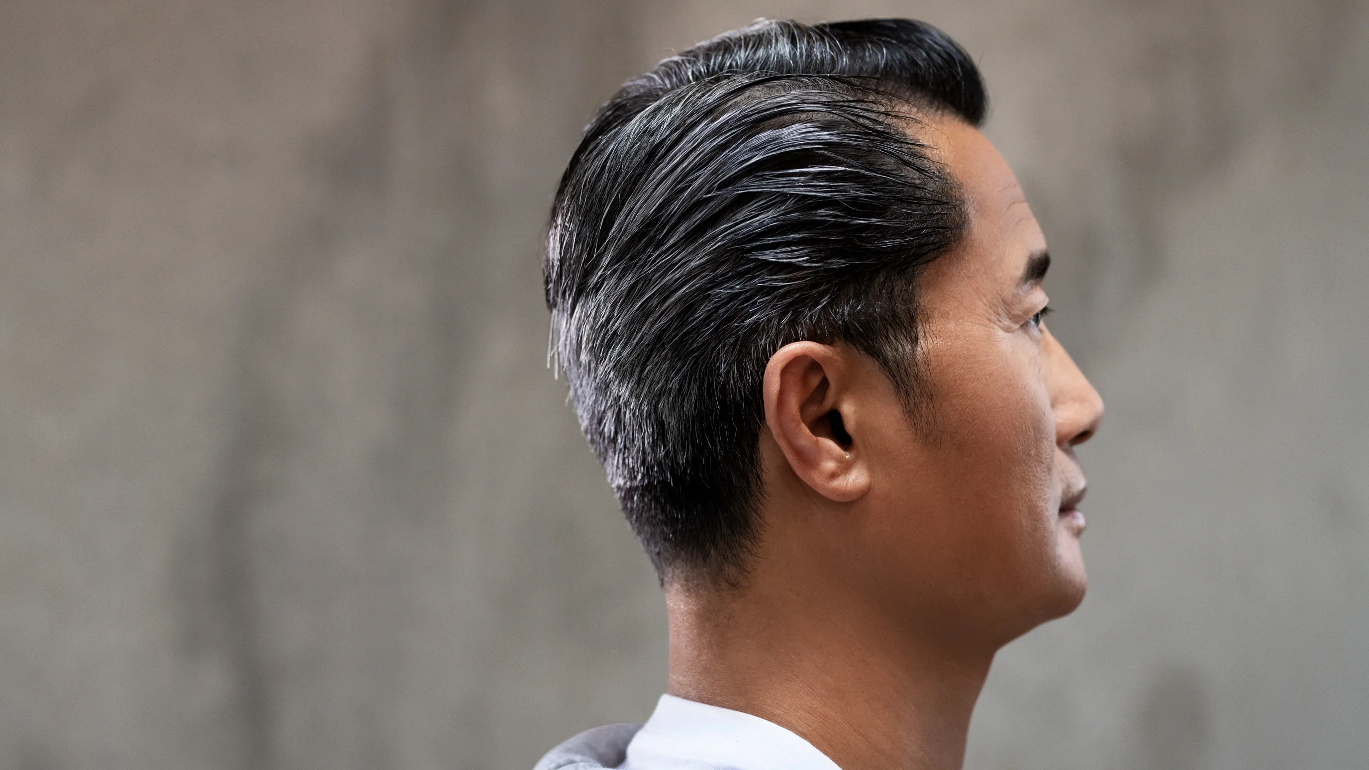 Wearing  nearly invisible hearing aids behind the ear