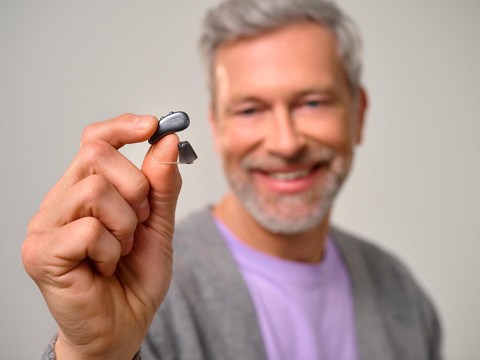 Man holding a hearing aid seeking support