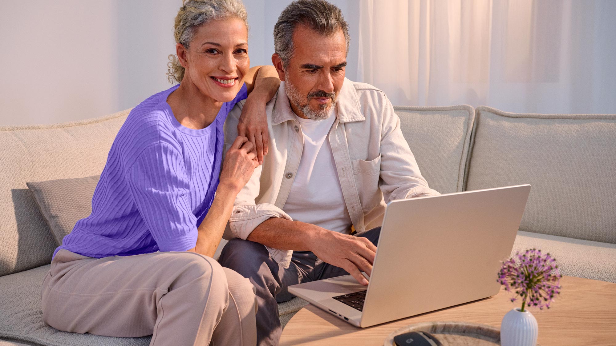 Casal esperançoso com tecnologia, ambos a usar aparelhos auditivos.