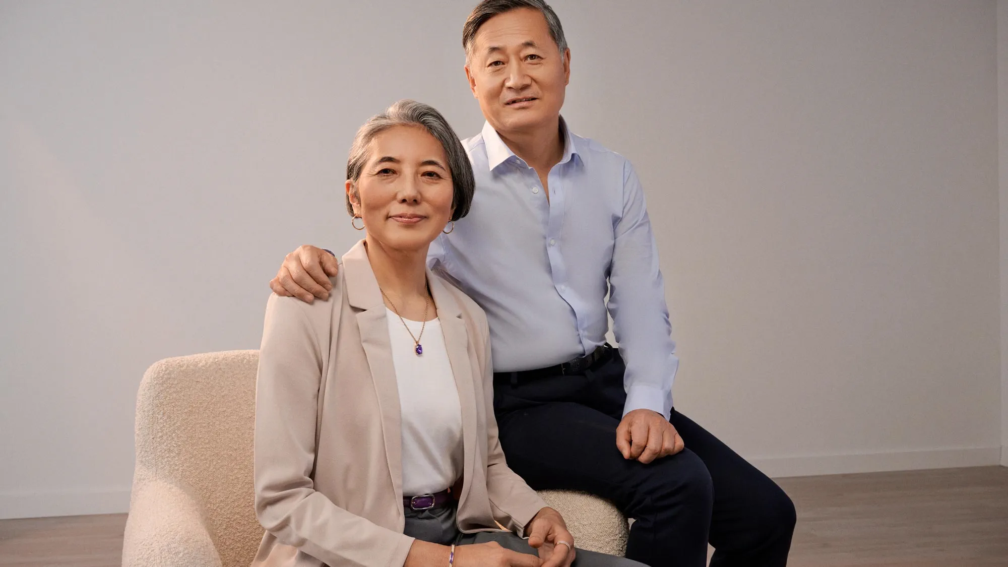 Man sitting beside his wife, placing a hand gently and supportively on her shoulder.