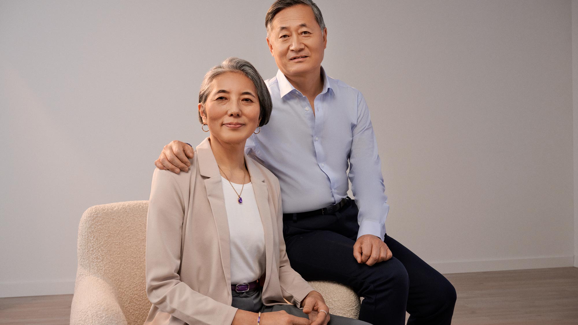 Man sitting beside his wife, placing a hand gently and supportively on her shoulder.