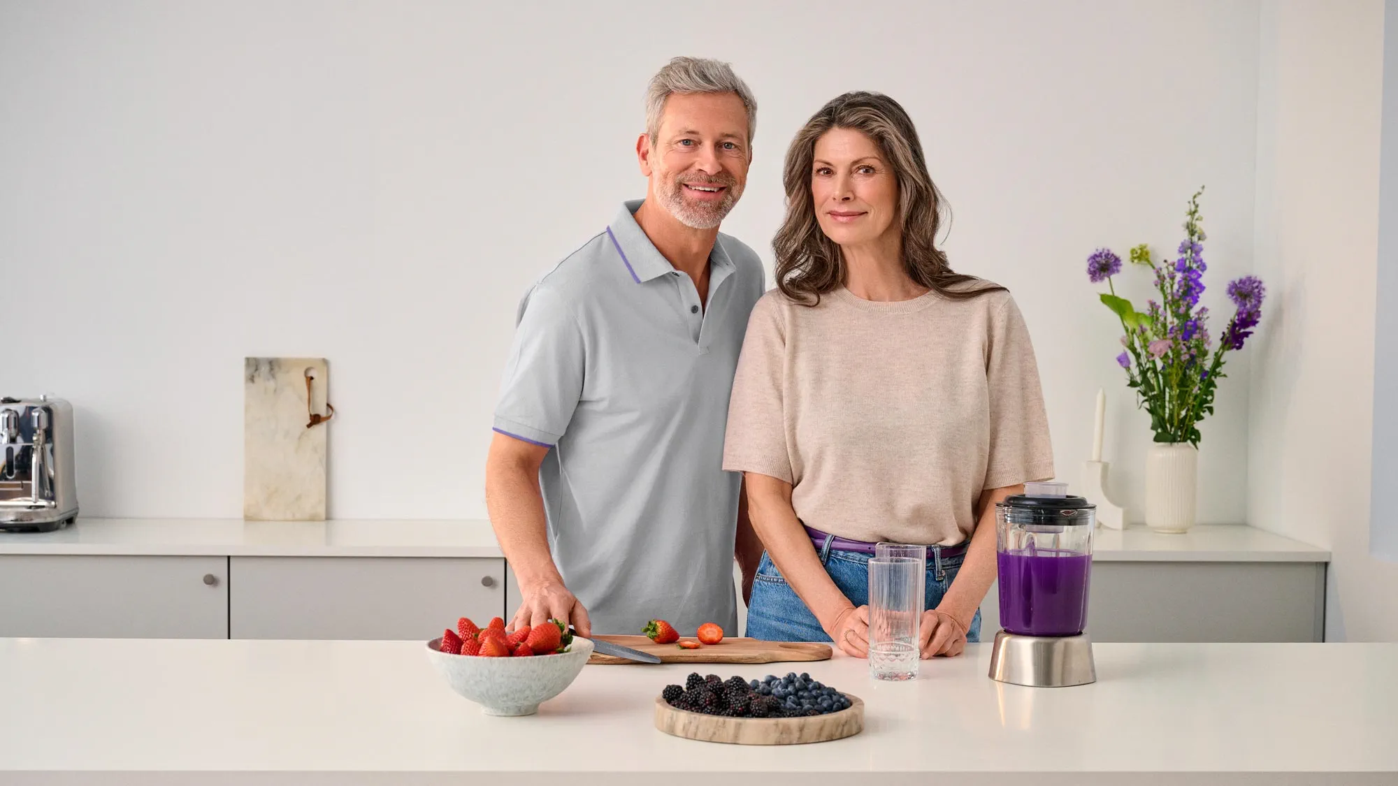 Casal a cozinhar junto na cozinha, ambos a usar aparelhos auditivos.