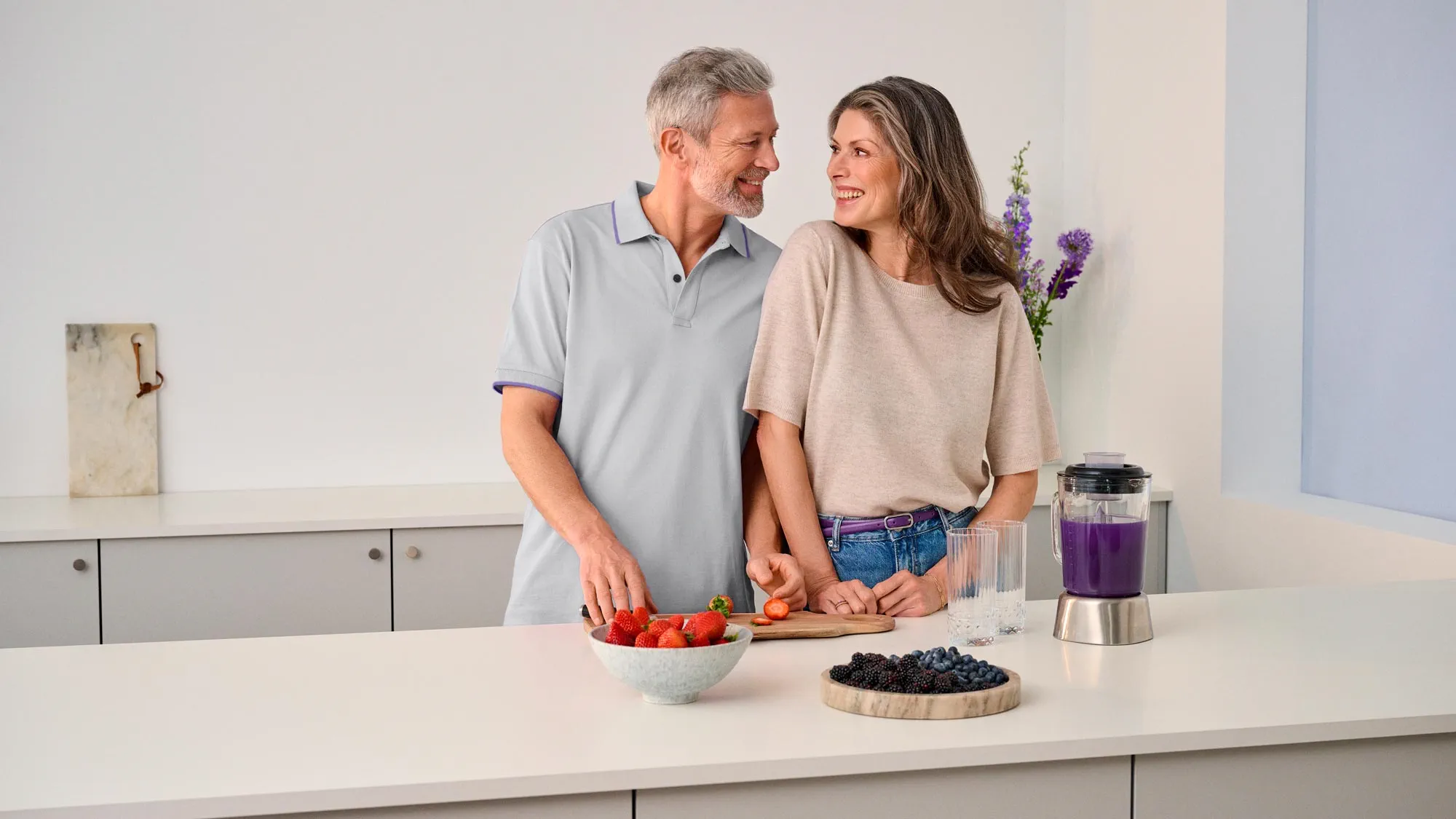 A couple looking at each other in the kitchen, sharing a moment of improved hearing.