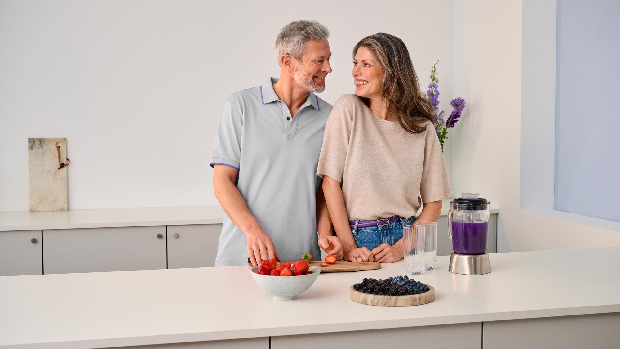 A couple looking at each other in the kitchen, sharing a moment of improved hearing.