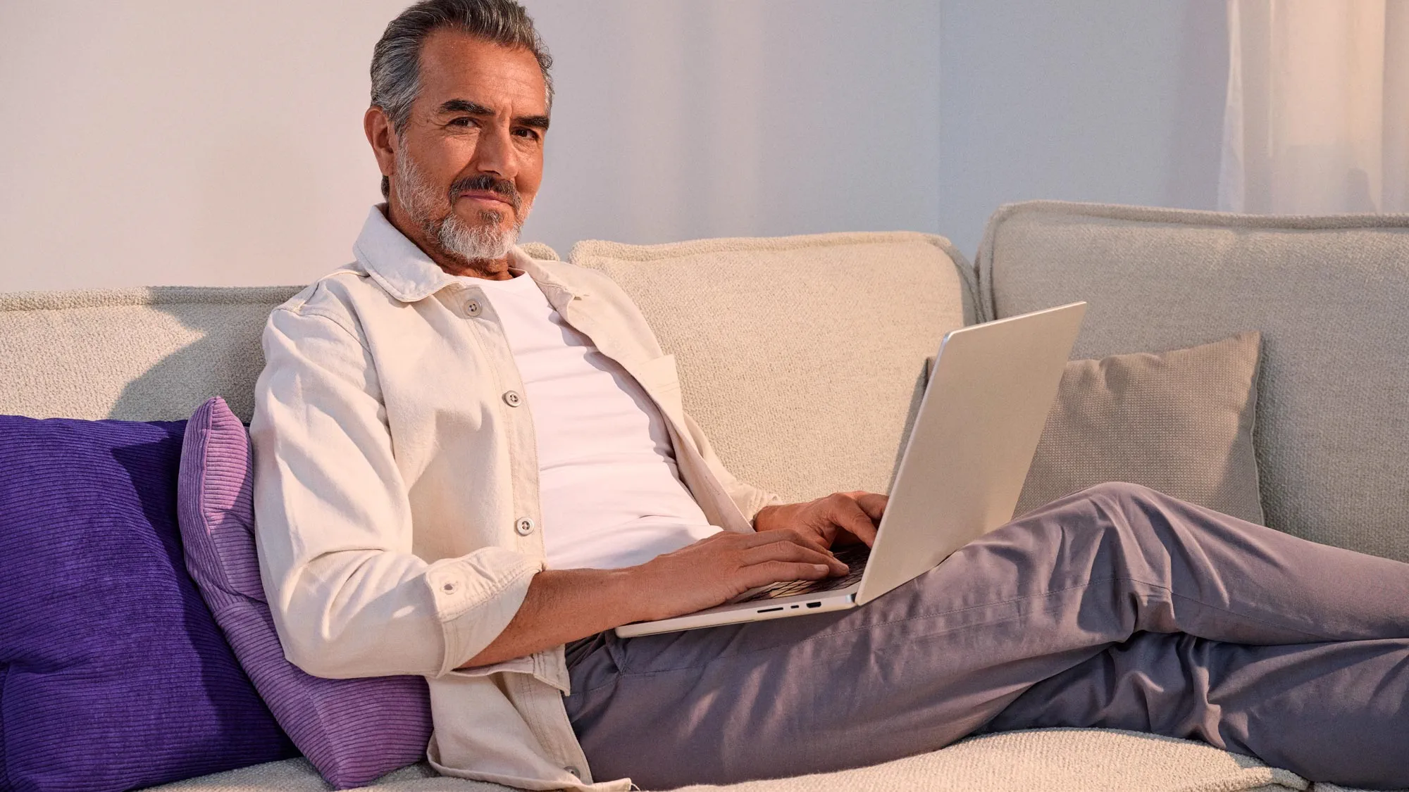 Relaxed man working on a computer, wearing hearing aids.