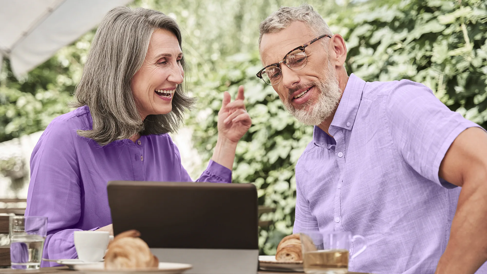 Couple hanging out at a cafe with help of hearing aids.