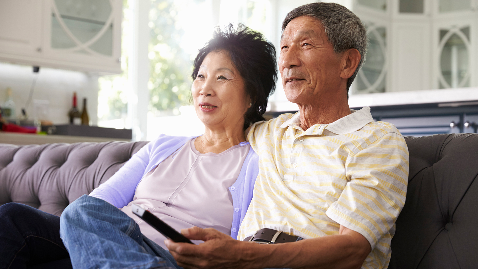 Couple watching tv at home is possible with the use of hearing aids