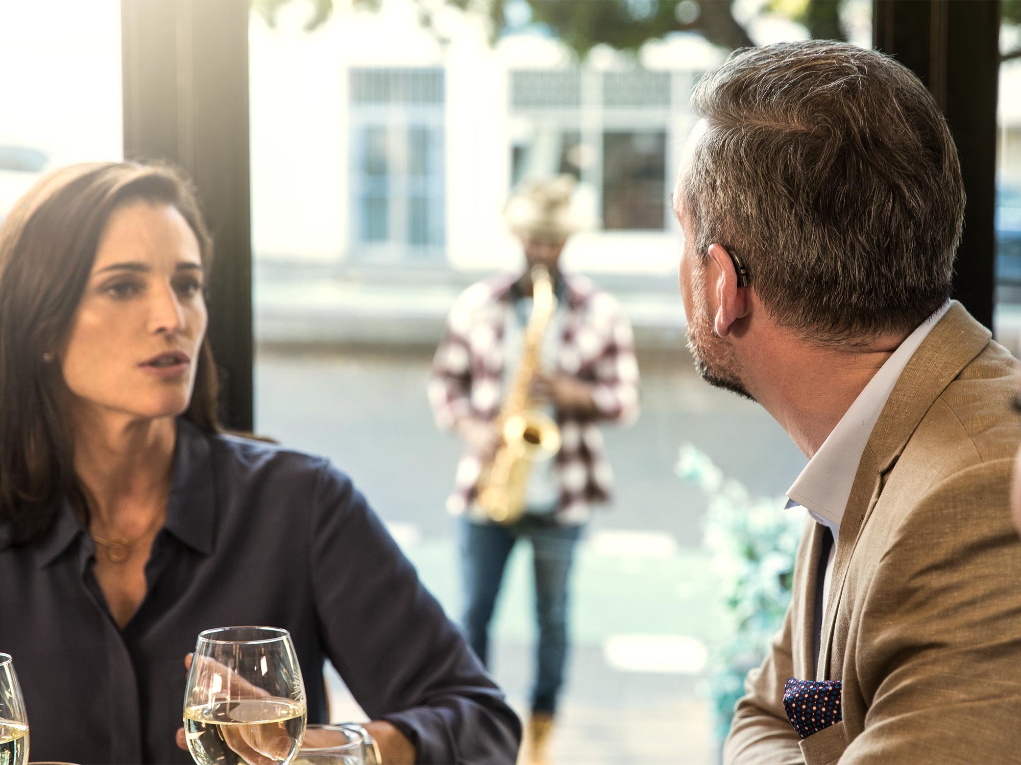 Friends enjoying a cup of coffee at a café using hearing aids
