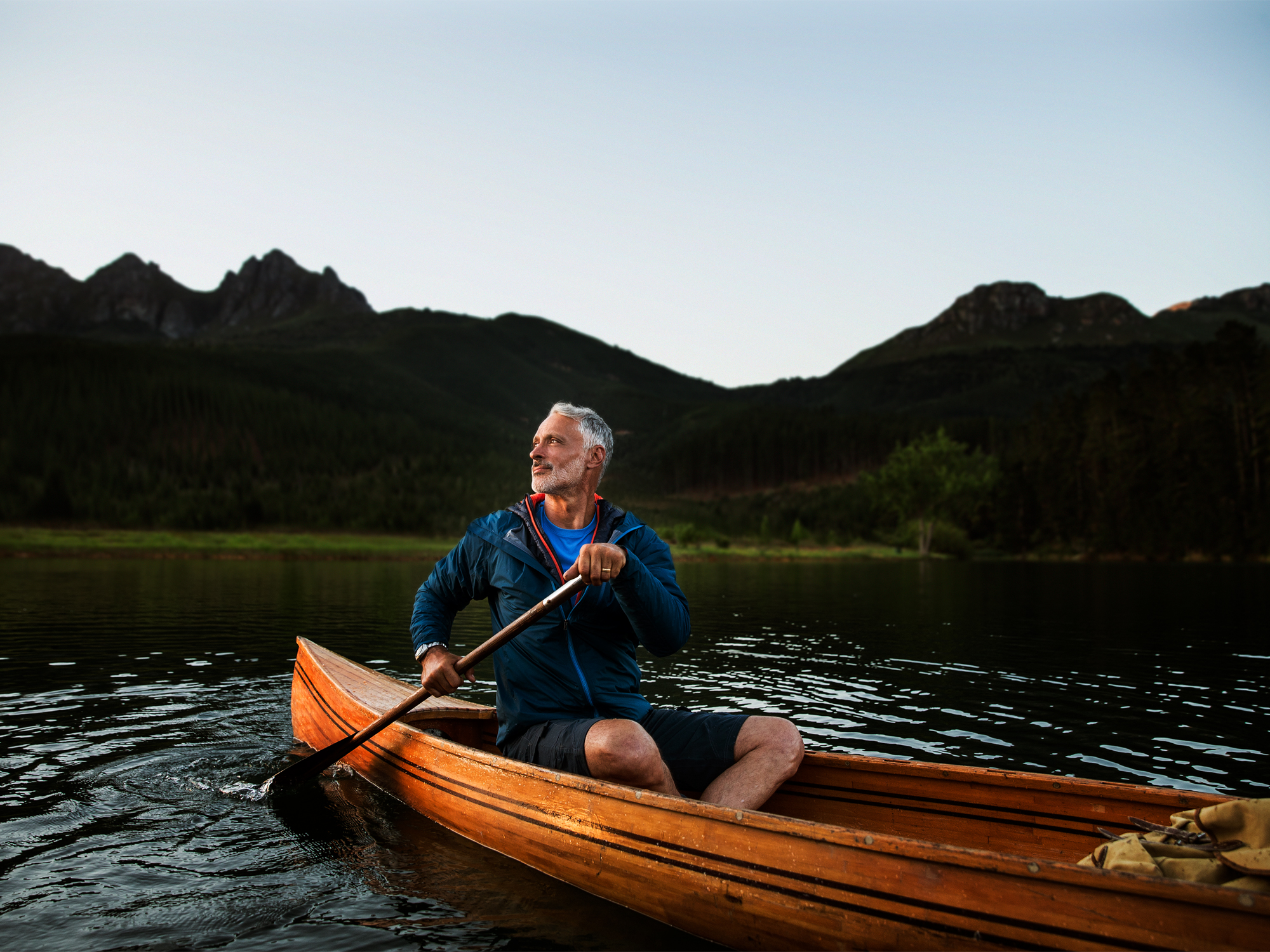 Man canoeing in a river using hearing aids