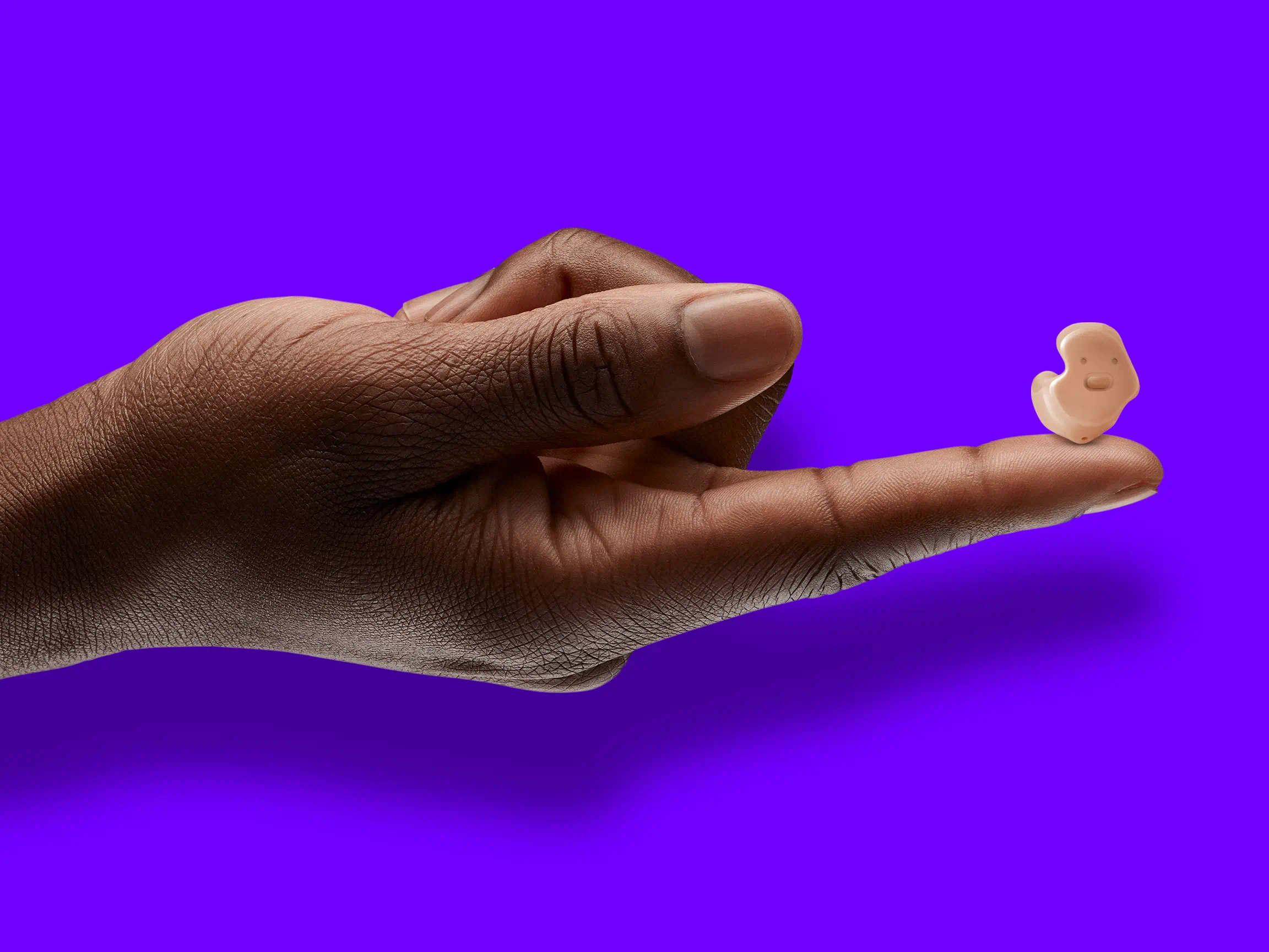 A hand holding Signia Insio Charge&Go CIC IX completely in canal (CIC) hearing aids.