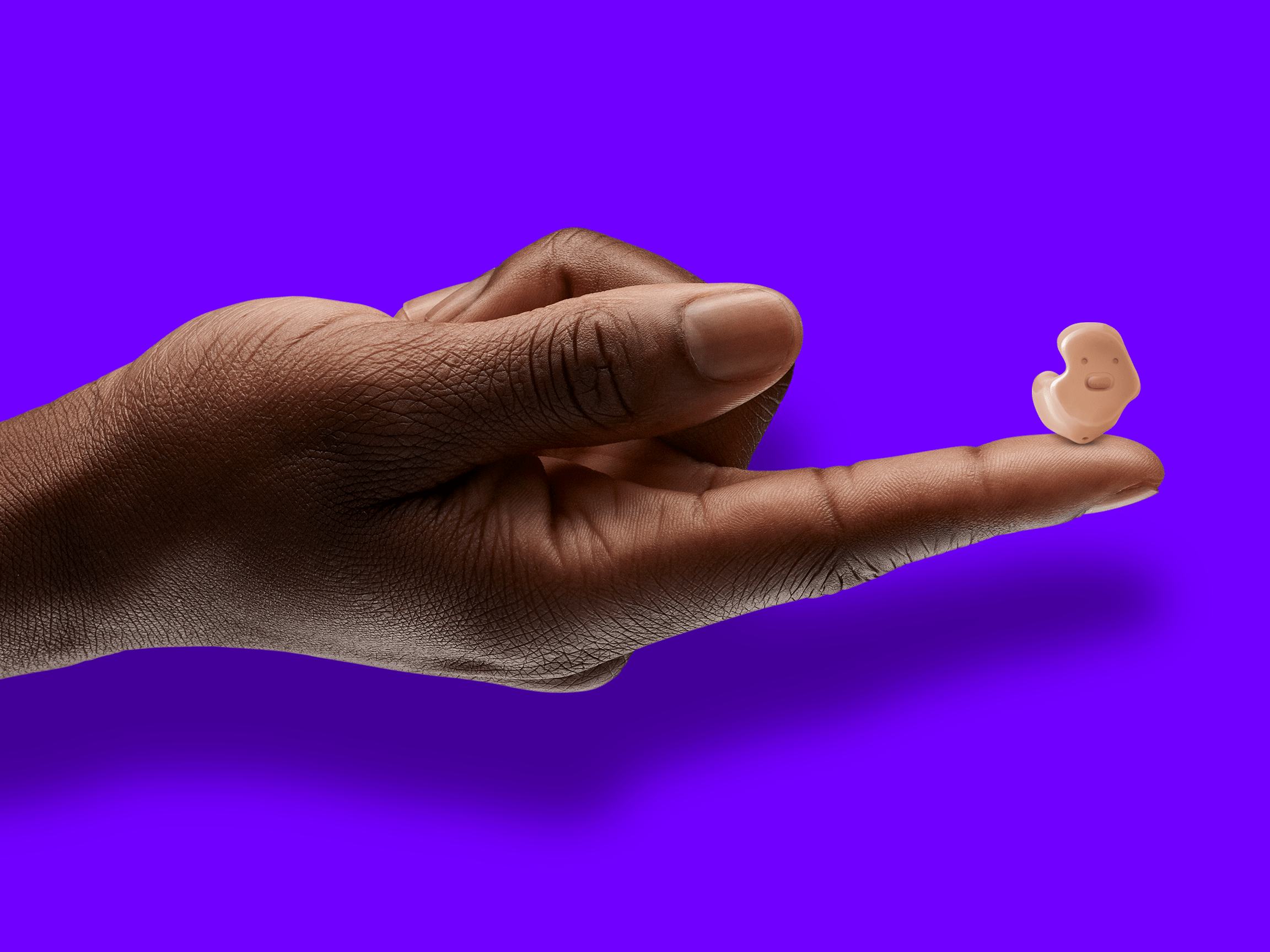 A hand holding Signia Insio Charge&Go CIC IX completely in canal (CIC) hearing aids.