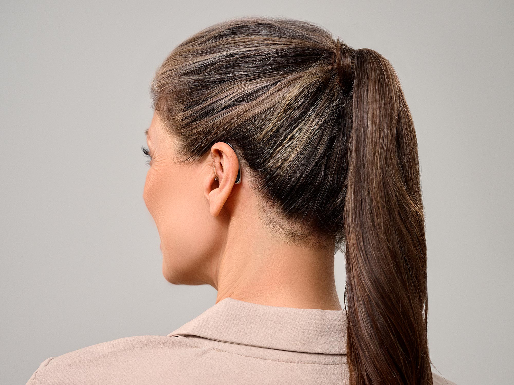 Woman viewed from the side wearing Signia Styletto hearing aids showing how small they are