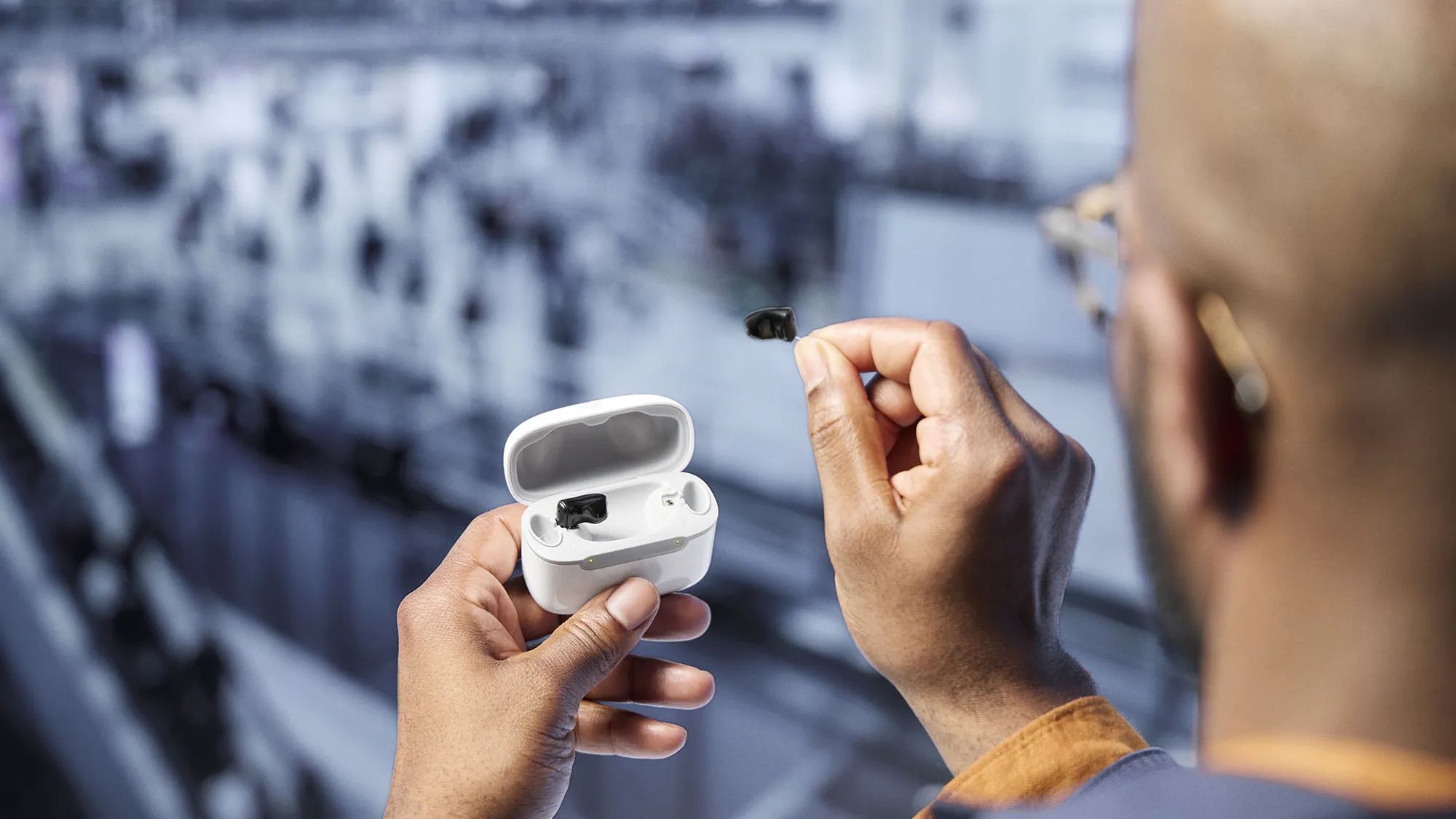 Signia Insio Charge&Go CIC IX hearing aids in chager held by man