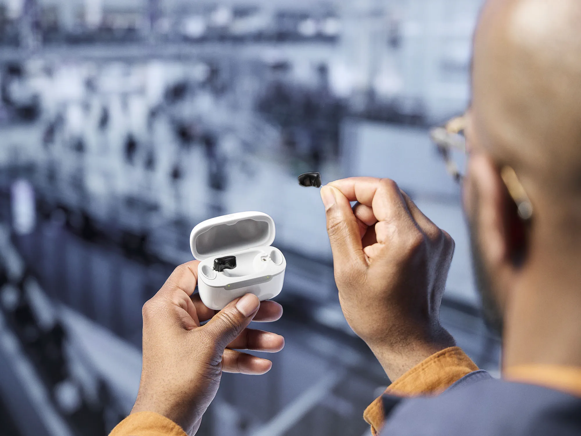 Signia Insio Charge&Go CIC IX hearing aids in chager held by man