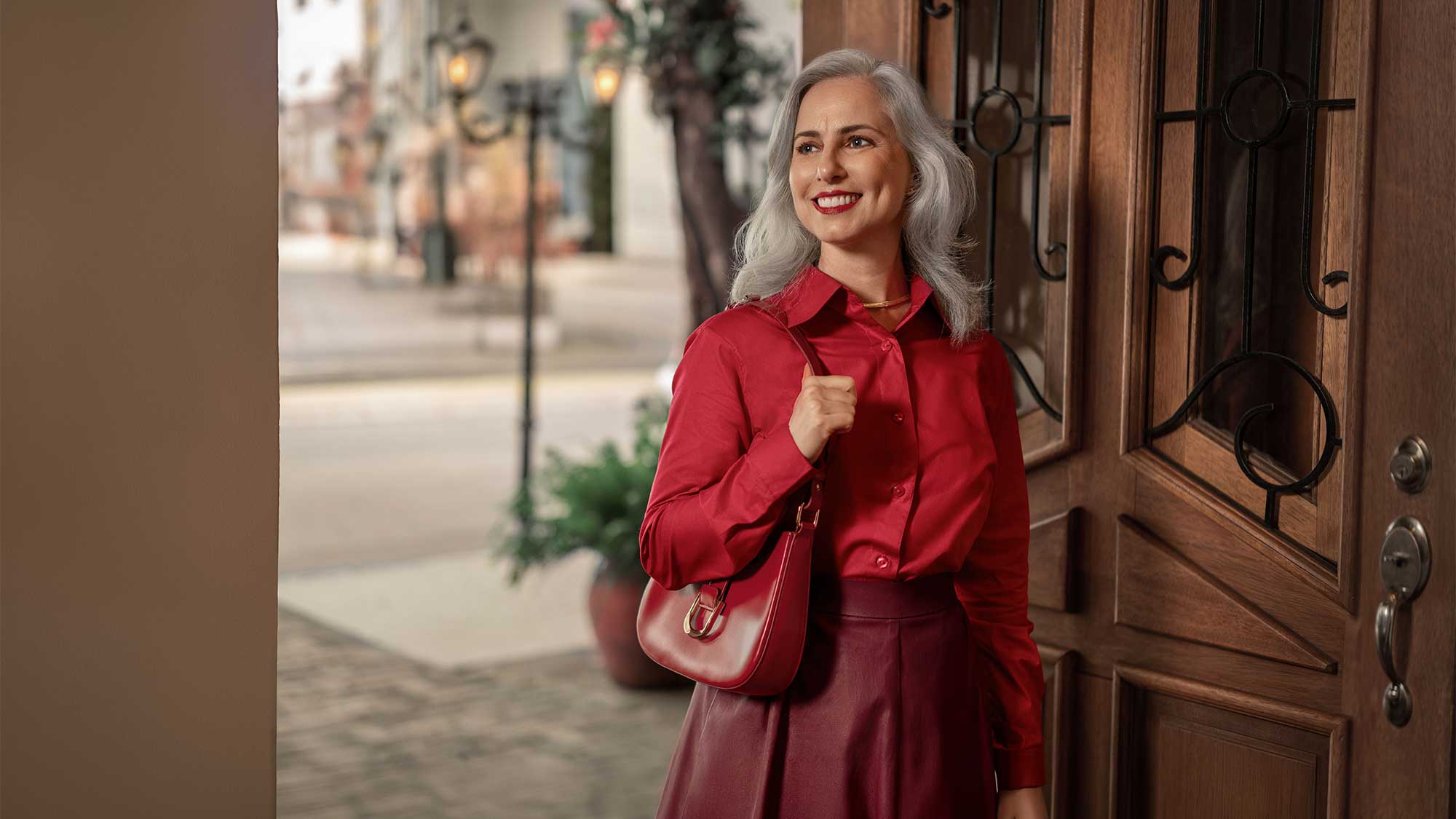 A woman standing in an urban setting wearing Signia hearing aids, highlighting style and advanced hearing-loss support