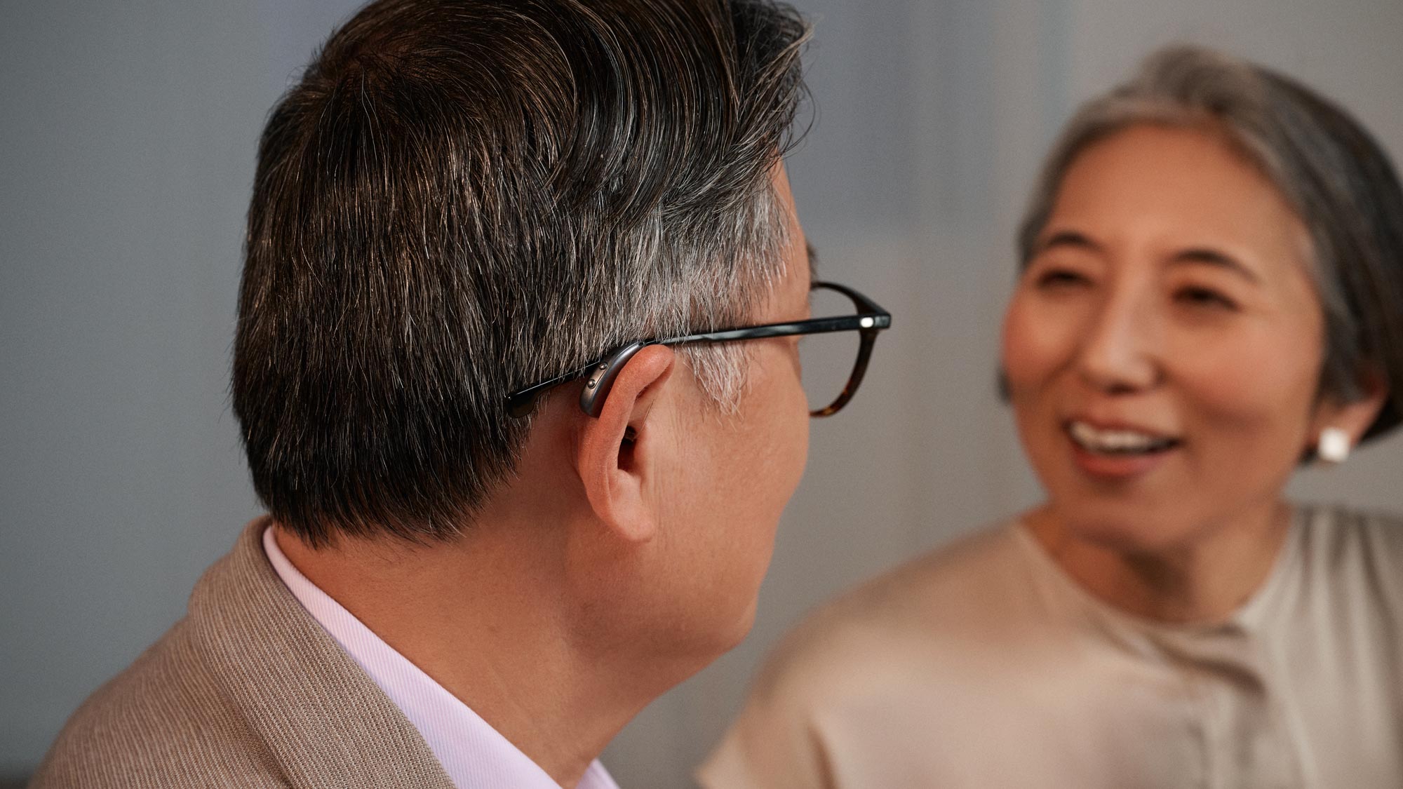Couple chatting with man wearing Widex moment RIC hearing aids.