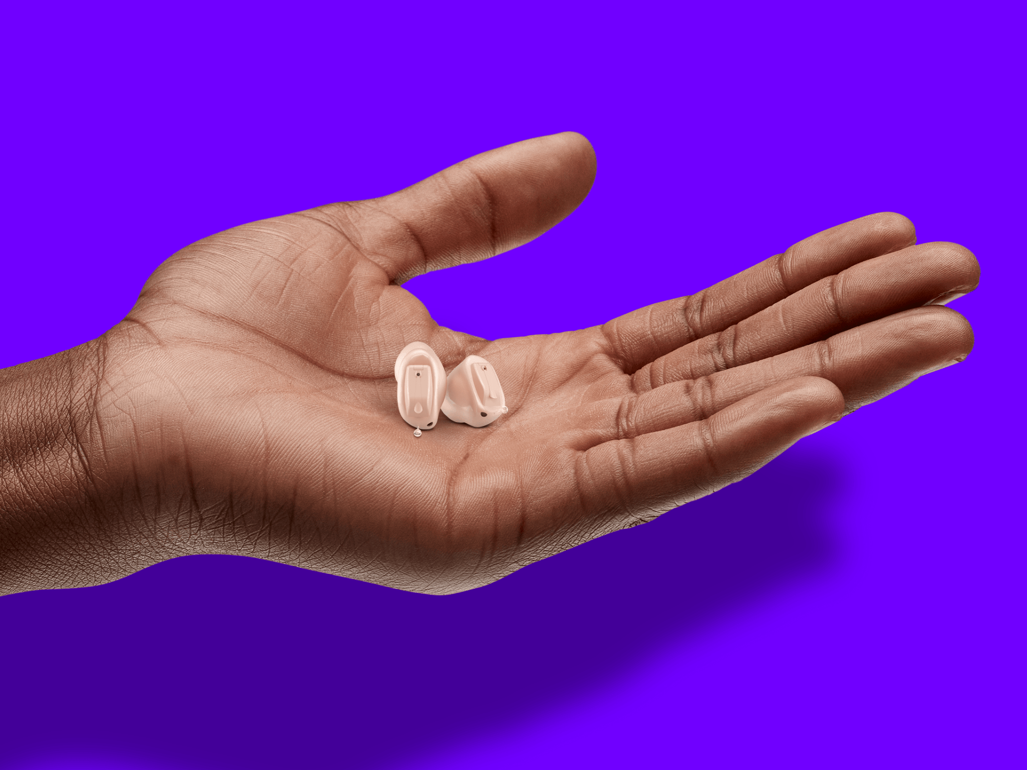 A hand is presenting the new hearing aids from WSA.