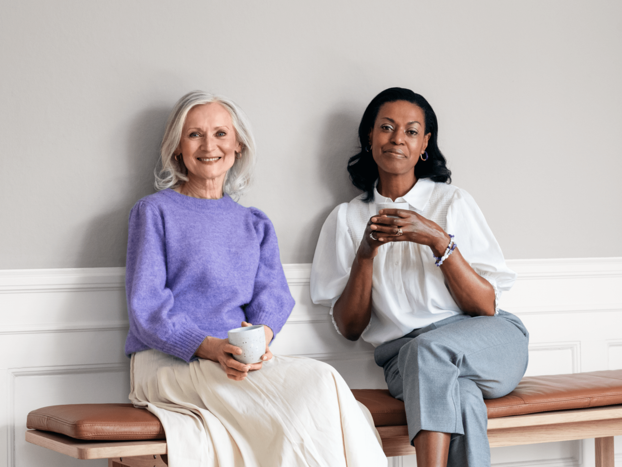 Two women are sitting together with talking about hearing loss issue.