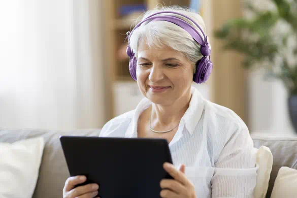 woman on tablet with headset hearing loss