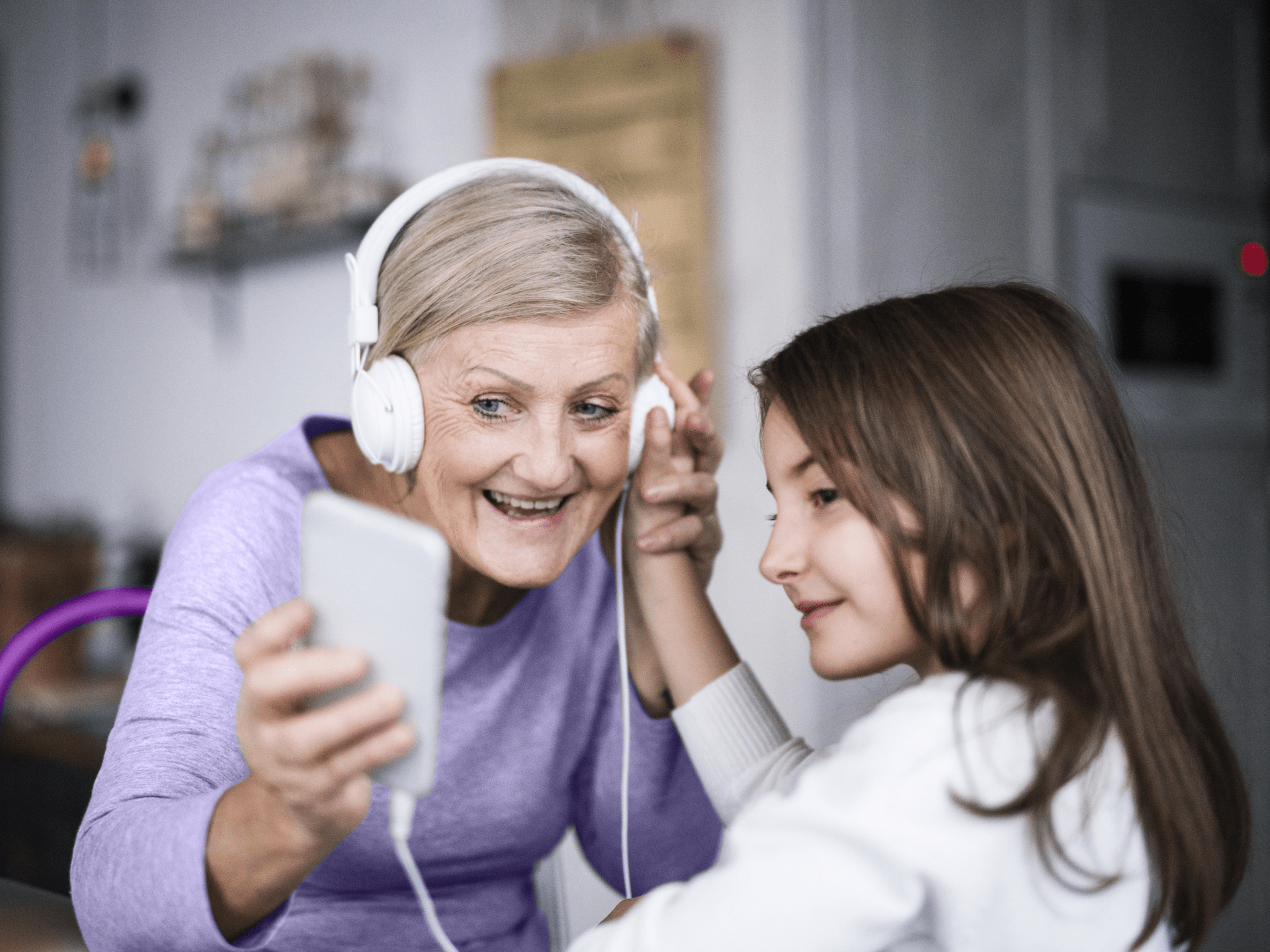 Granma showing young girl tablet hearing aids