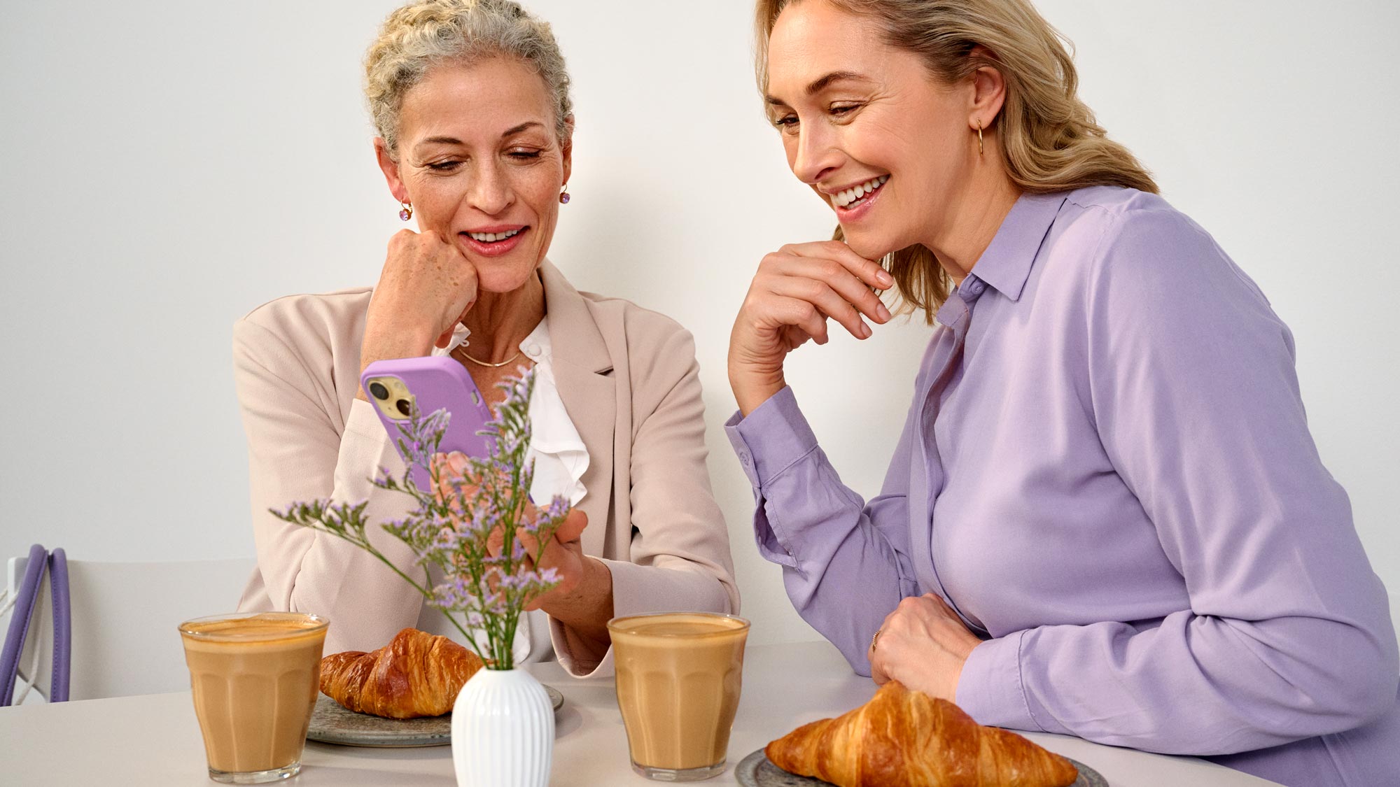 friends having coffee wearing bluetooth hearing aids