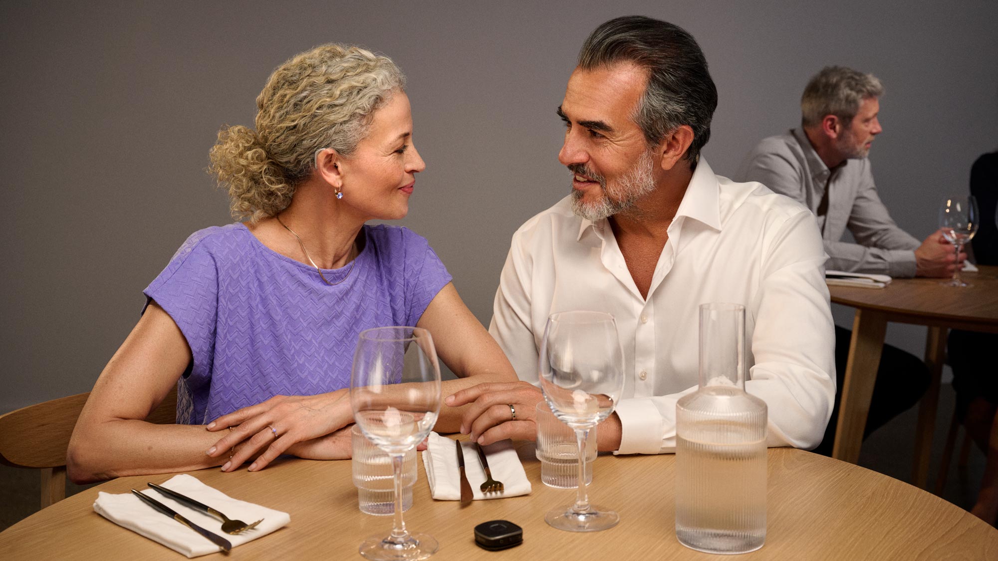 man and woman having dinner, wearing hearing aids