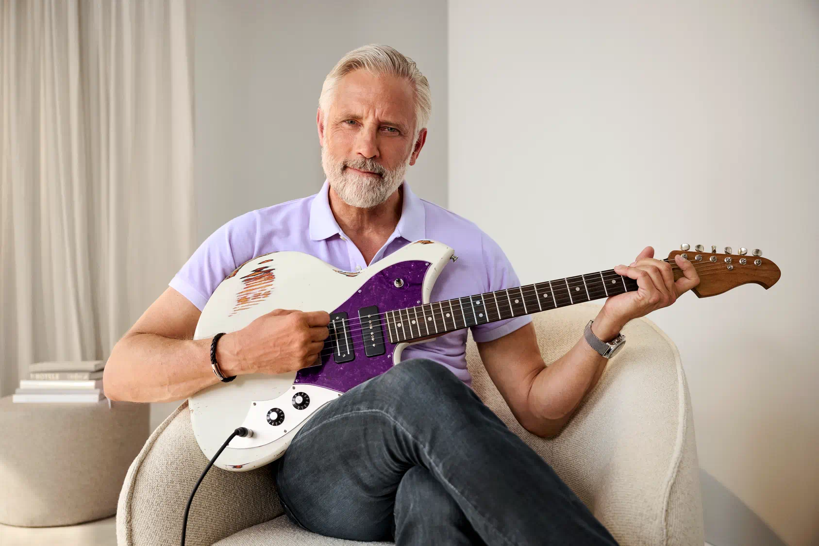 man playing guitar with hearing aids
