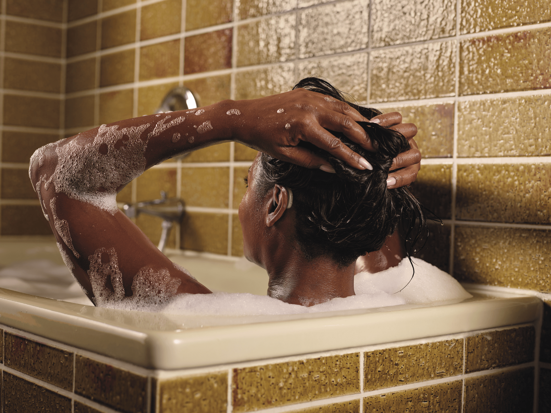 Woman taking a bath with her water-resistant hearing aids on