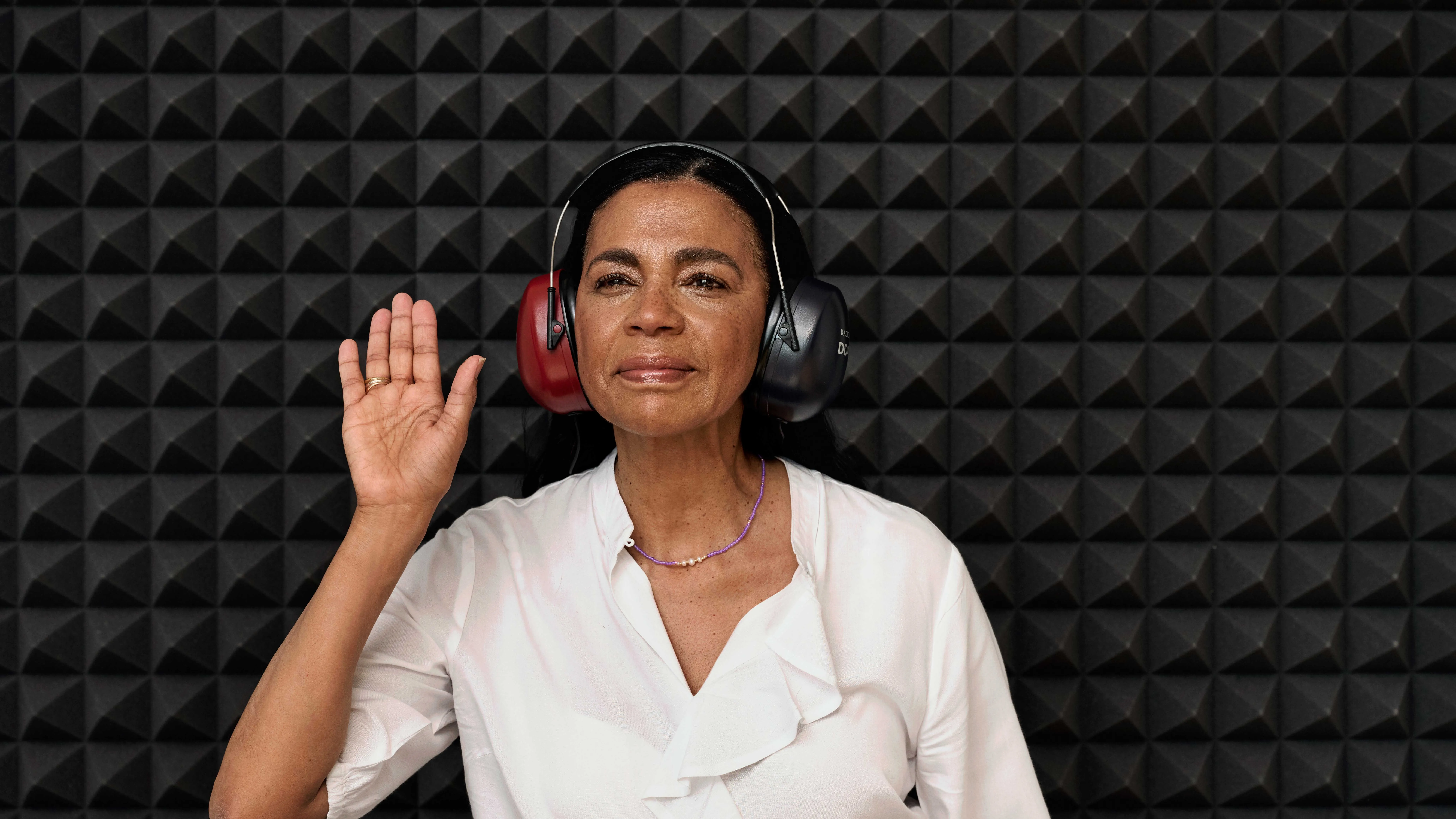 Woman in a sound booth undergoing a hearing test for potential hearing loss.