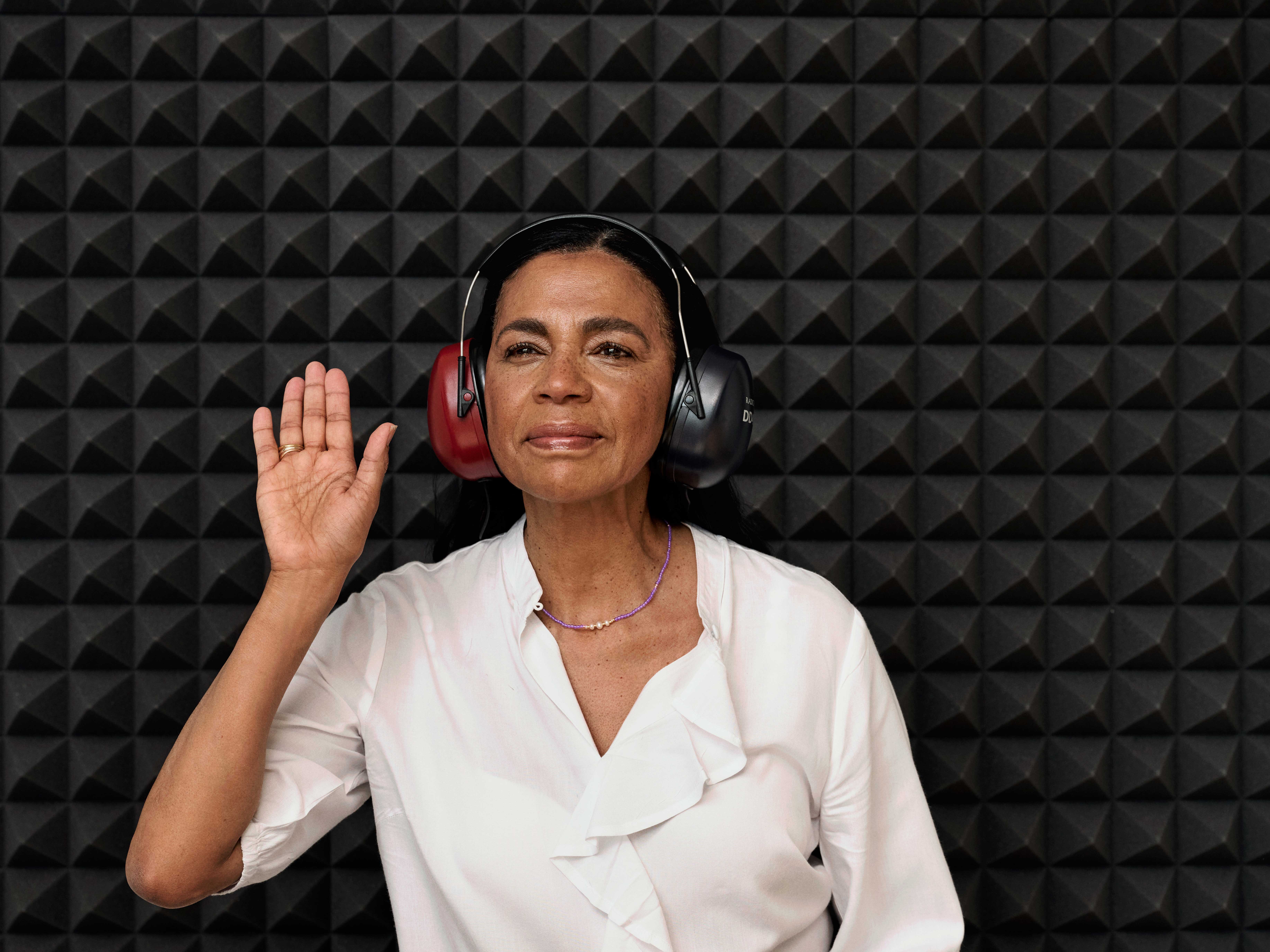 Woman in a sound booth undergoing a hearing test for potential hearing loss.