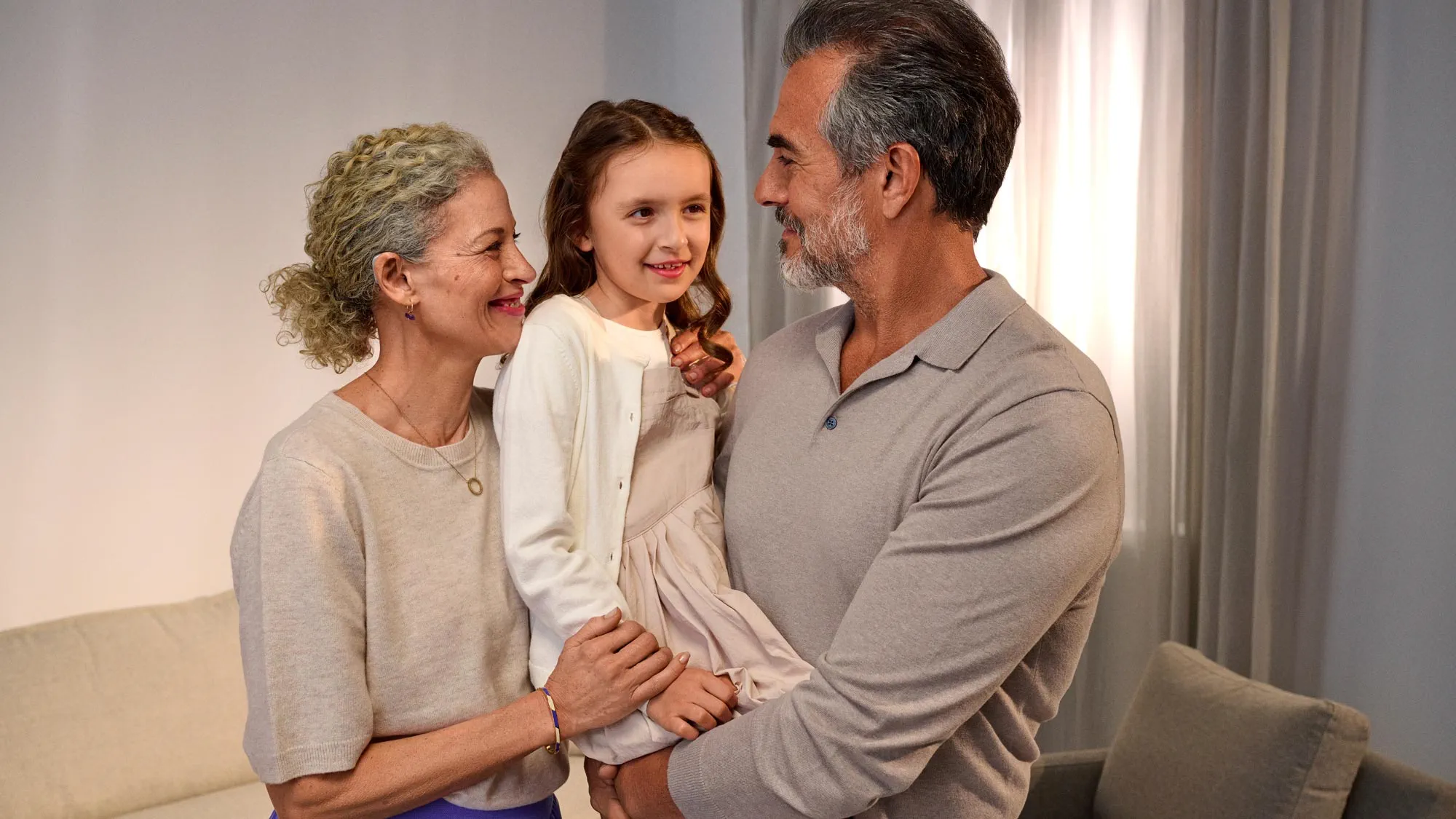 happy family with their child, wearing hearing aids