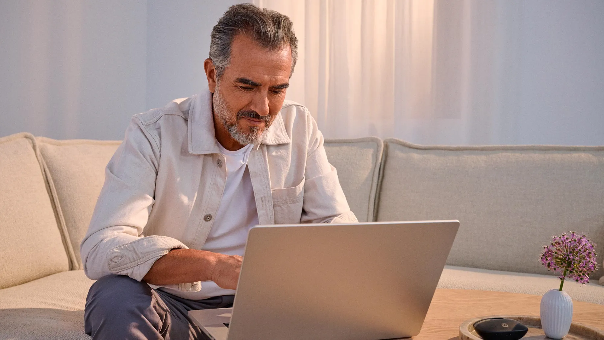 man on a laptop, taking the online hearing test at hearusa