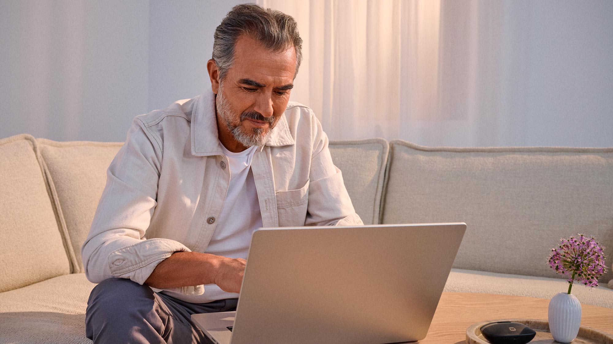 man on a laptop, taking the online hearing test at hearusa