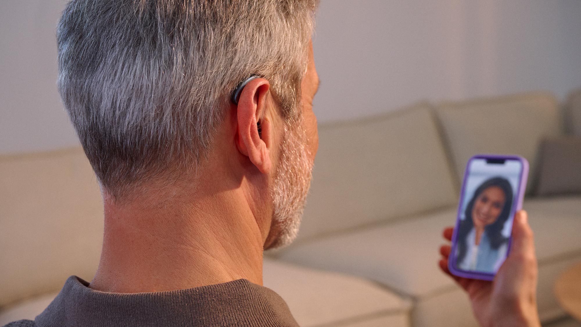 Man on a call using a hearing aid