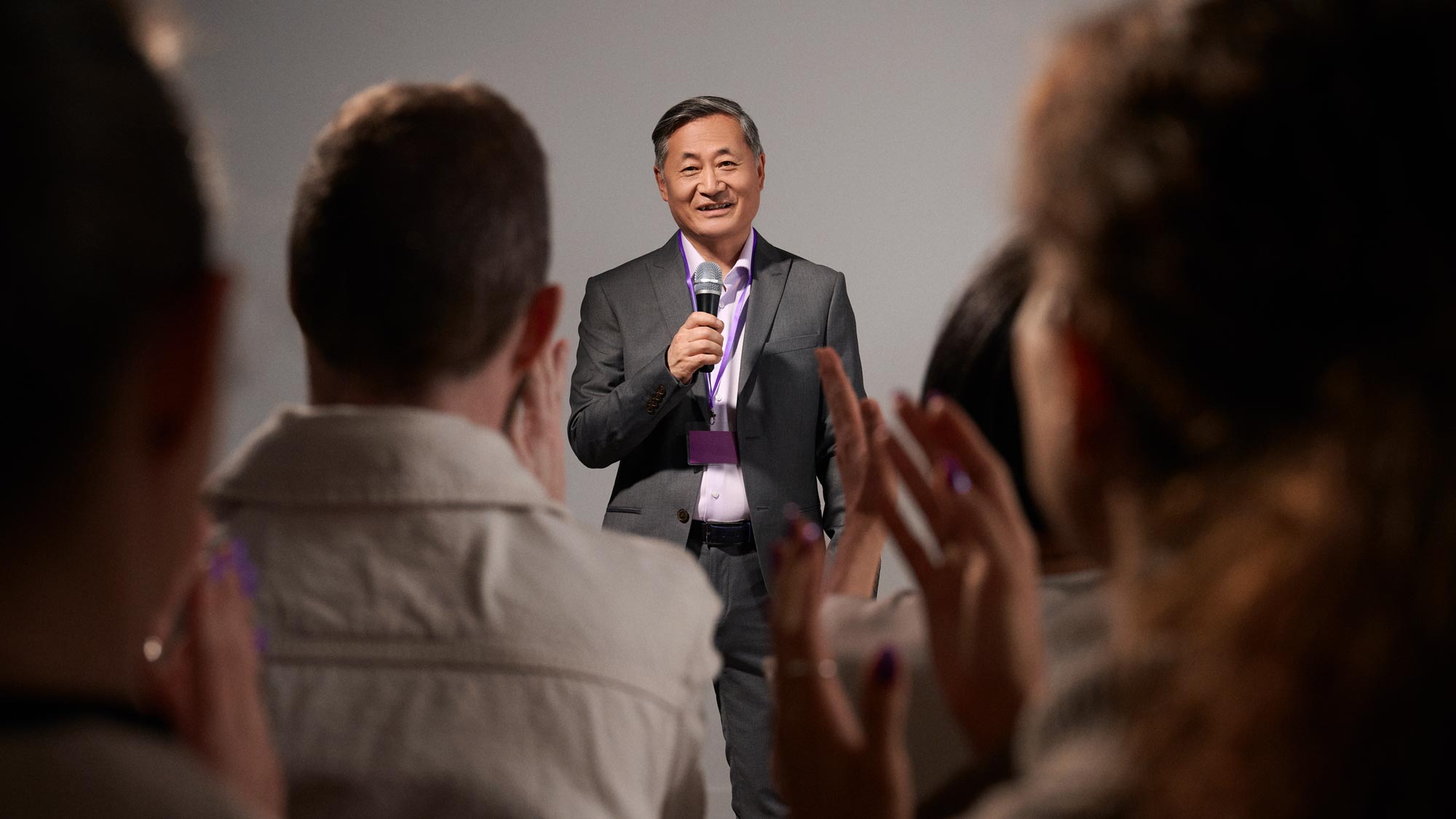 Man presenting to an audience, confidently wearing hearing aids.