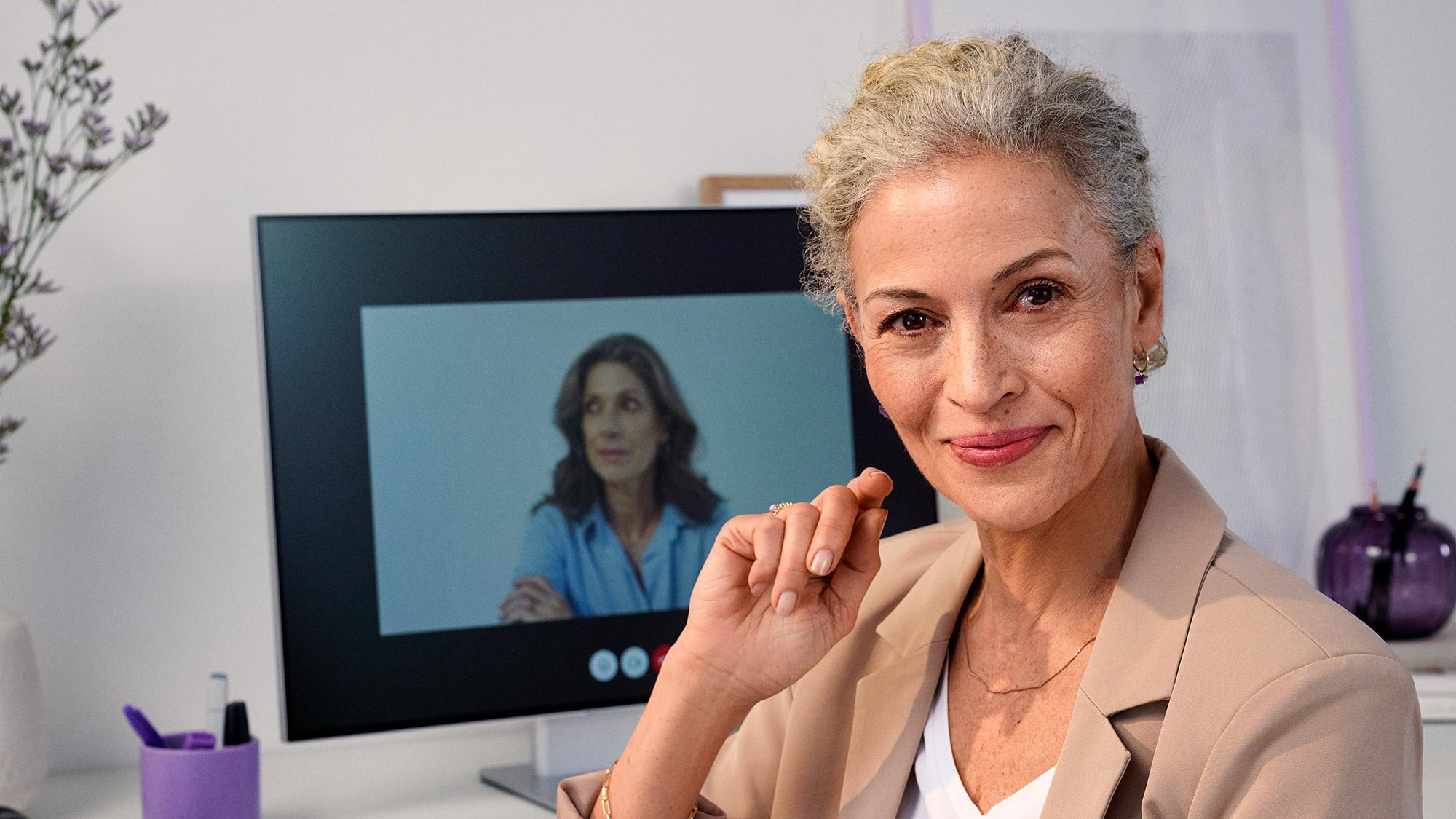 Woman in an office meeting, participating confidently with her hearing aids.