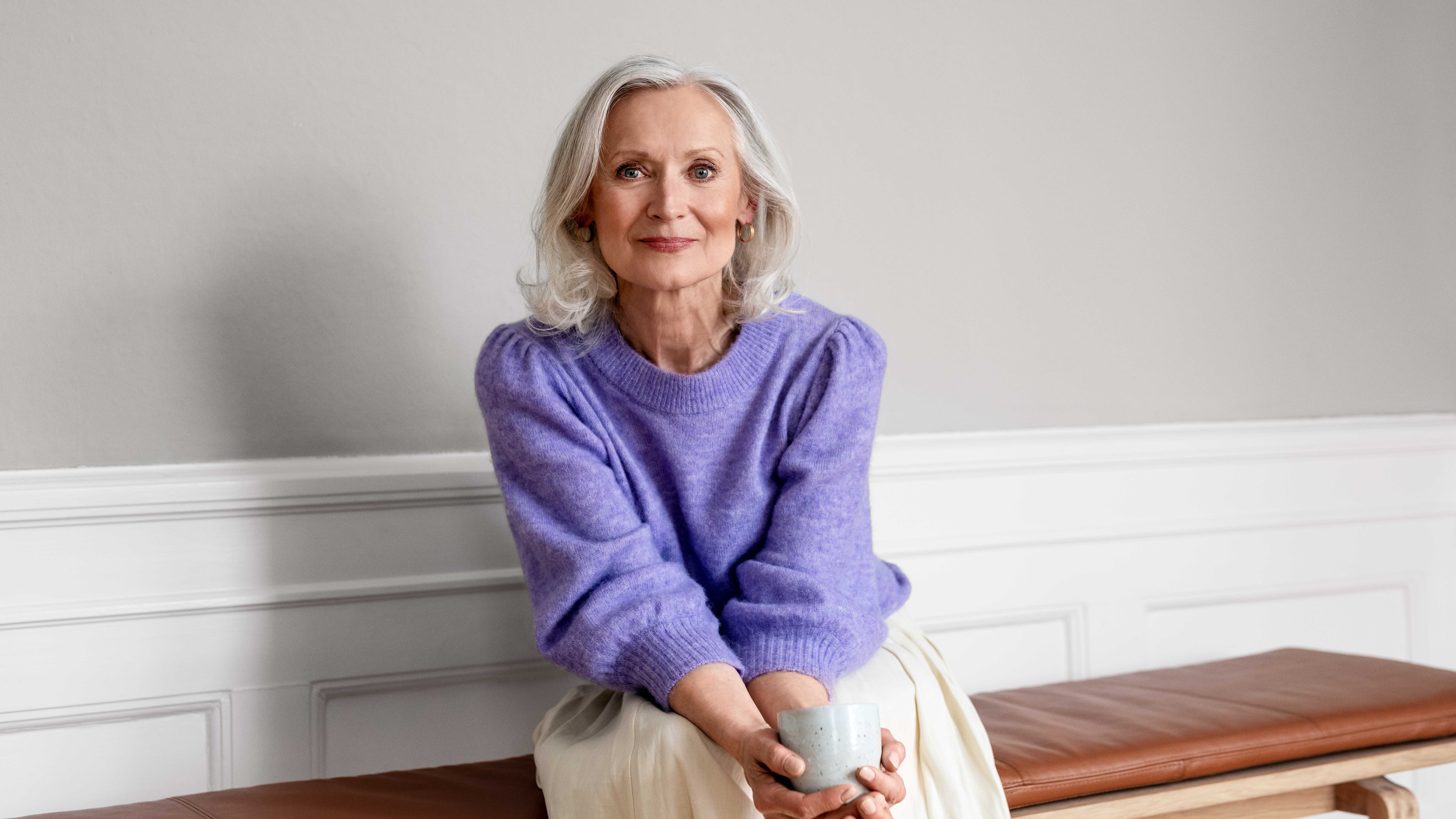 Woman sitting on a bench with coffee, enjoying a peaceful moment.