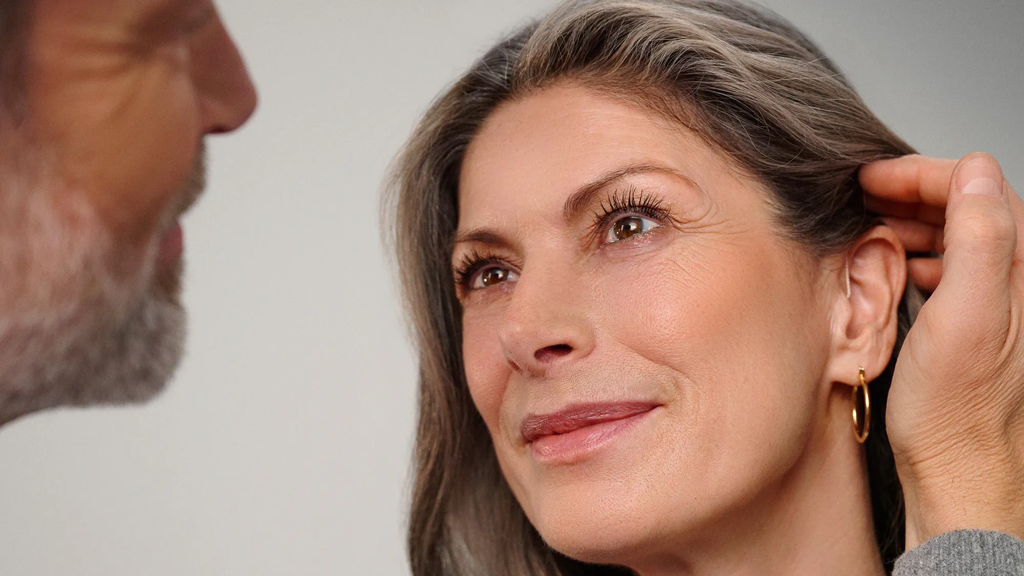 Couple sharing an affectionate moment, with hearing aids visible.