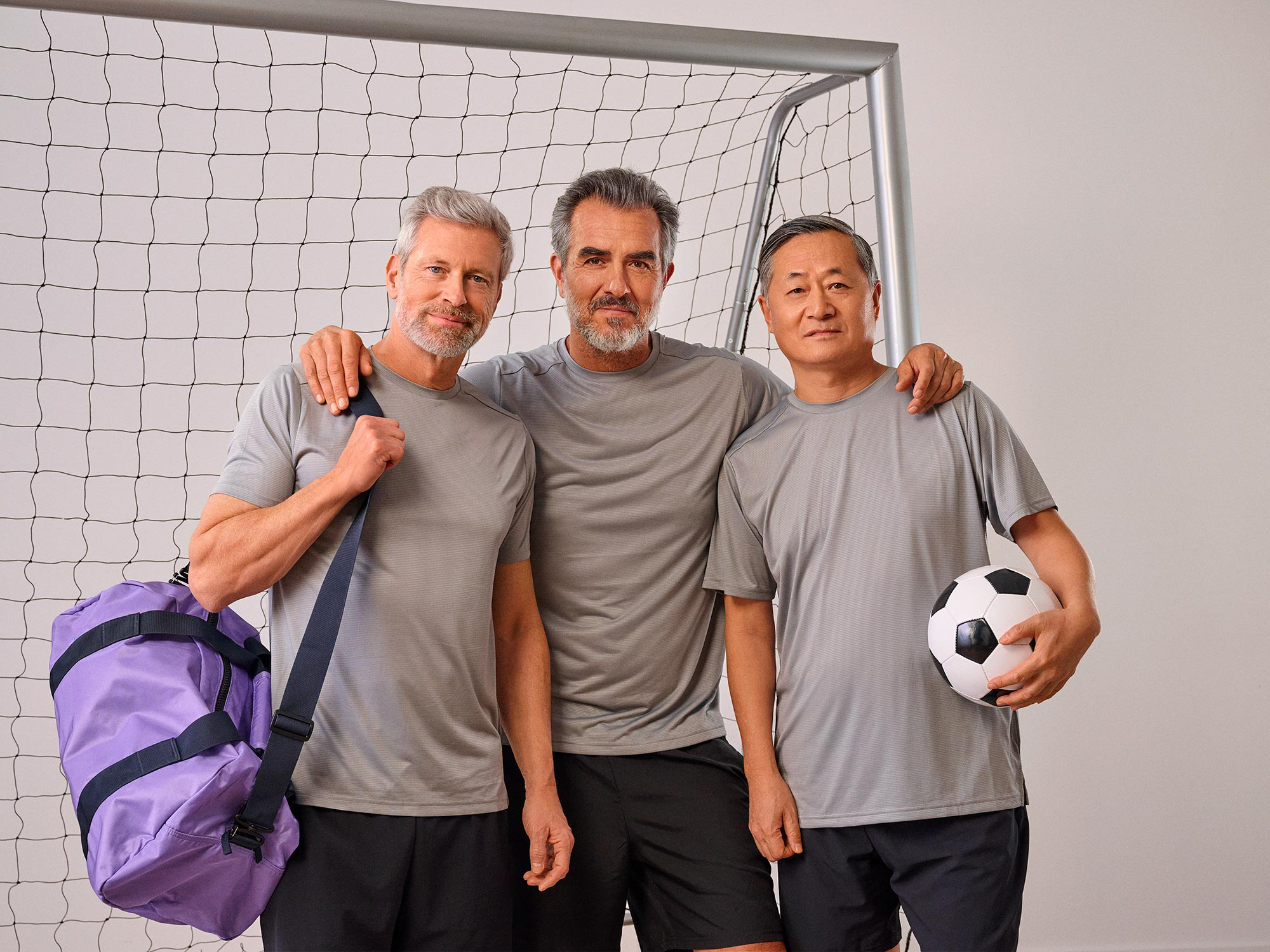 Friends playing football together, some wearing hearing aids.