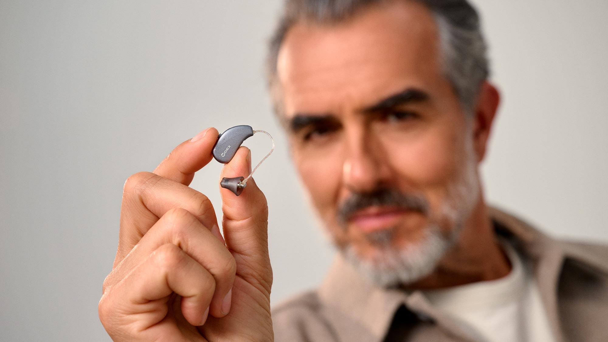 hearusa man holding hearing aids