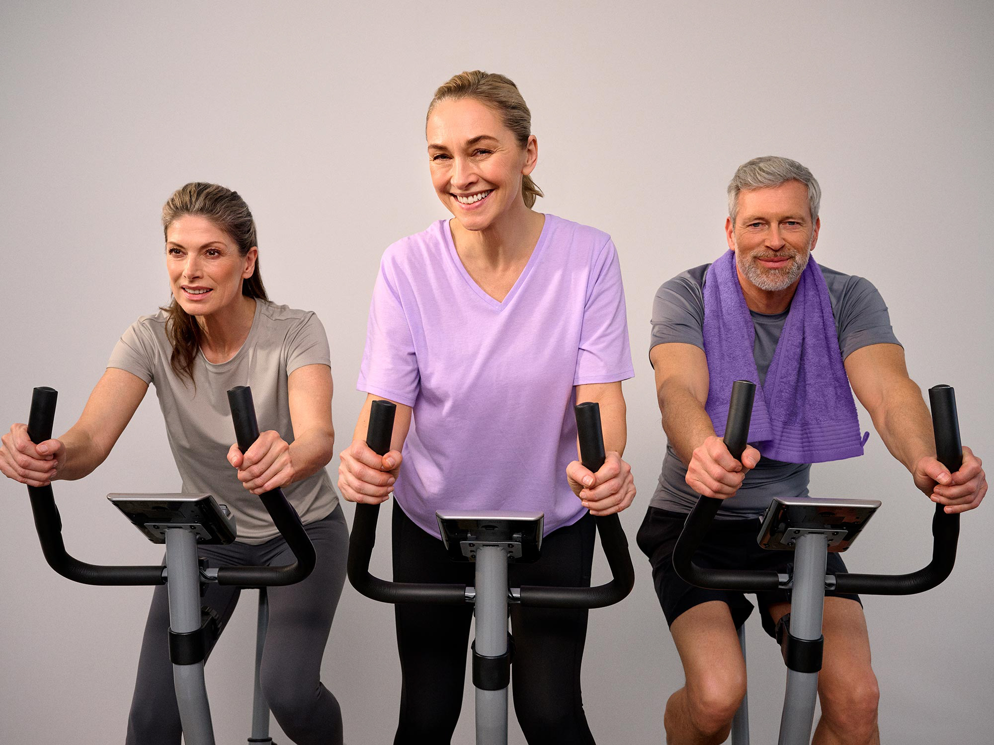Friends enjoying a spinning class, wearing hearing aids for clear communication.