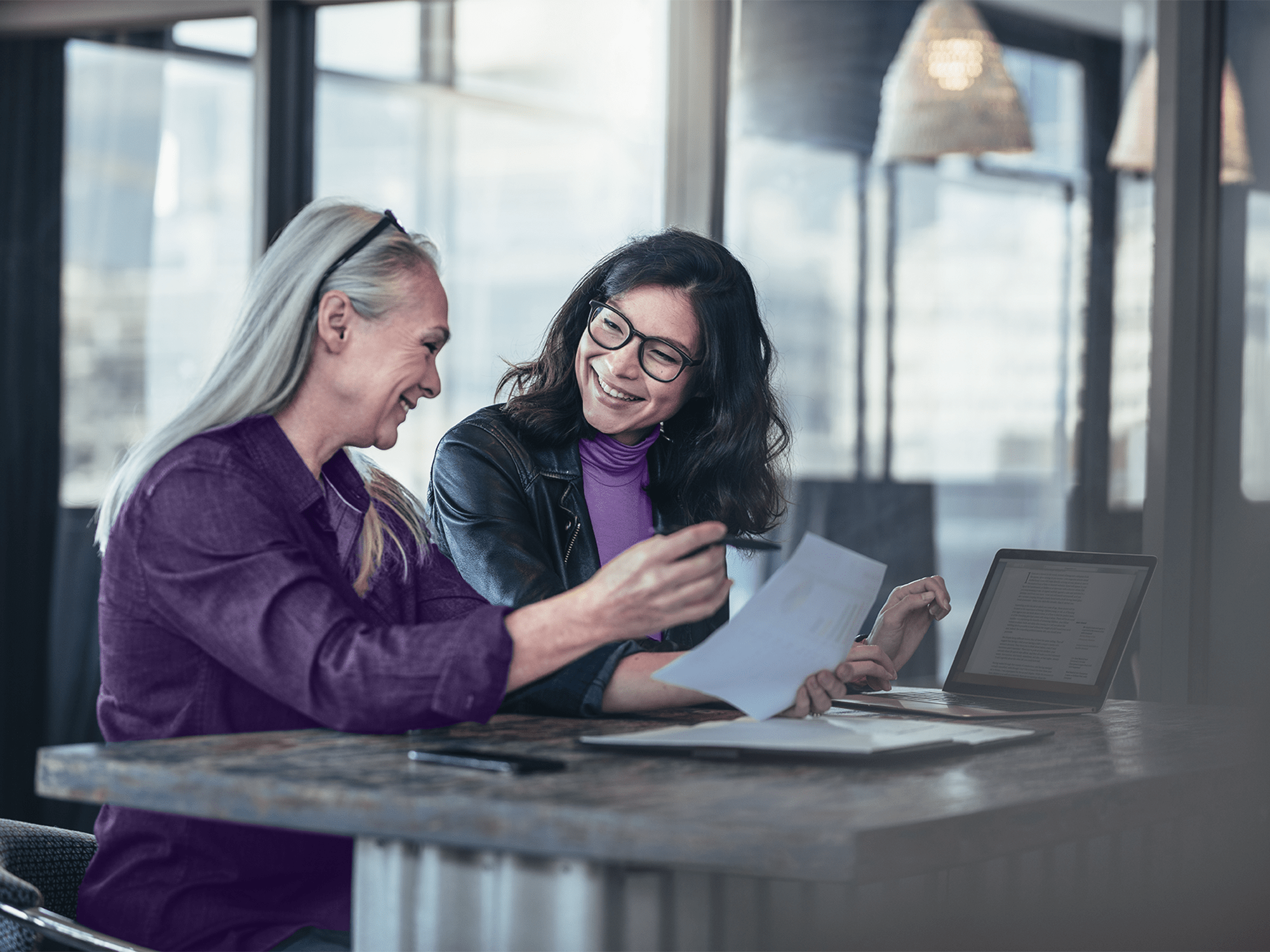 Smiling business woman working together on contract documents. Happy coworkers meeting for new project planning in office.